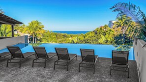 Relax by the pool, with comfortable chairs overlooking the serene ocean.