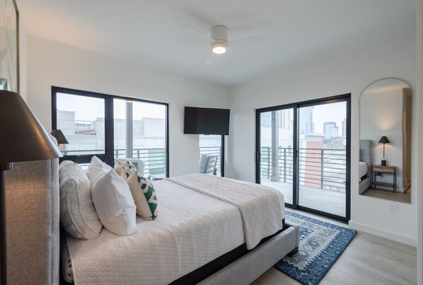 Spacious bedroom with large windows providing natural light and offers a stunning city view, creating a serene and relaxing atmosphere