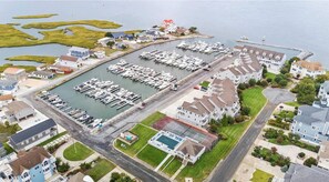 Aerial view of townhouse, marina, pool, and tennis court. 