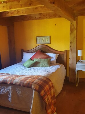 Spacious room bathe in the glow of  yellow lime wash plaster and golden beams. 
