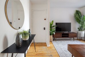 Entryway view with round mirror and inviting lounge space