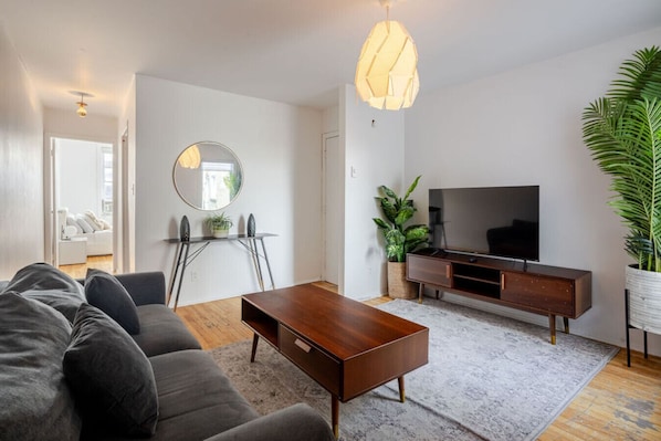 Bright living area with TV, coffee table, and greenery