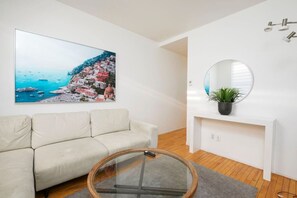 Living Room: Minimalist charm meets comfort with soft neutrals and rounded decor touches