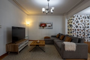 Comfortable lounge with large sofa, TV setup, and ambient lighting