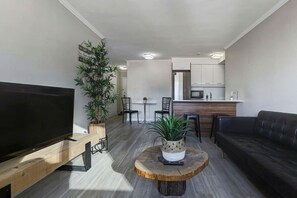 A spacious and stylish open-concept living area with modern touches, natural light, and a seamless flow into the kitchen