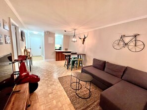 A spacious lounge area with a cozy sectional, unique wall art, and an inviting ambiance