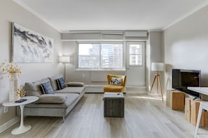 A spacious and well-lit lounge space, offering city views and a comfortable setting for relaxation.