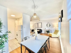 A modern dining space with stylish lighting, lush greenery, and an airy, open design for a refreshing ambiance.