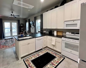 Fully modern kitchen with brand new appliances and equipped to support family meals and retreats. If you need it and can't find it, just ask us, we can probably help out. We live across the street, and we are good neighbors! Note the eat at bar.