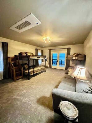 This bunkroom is almost identical to the other one. Featuring a spacious room with bunks designed for adult comfort along with a queen-sized sleeper sofa. Everyone has the opportunity to fall asleep and wake up to a lake view! 