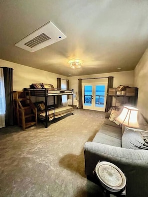This bunkroom is almost identical to the other one. Featuring a spacious room with bunks designed for adult comfort along with a queen-sized sleeper sofa. Everyone has the opportunity to fall asleep and wake up to a lake view!