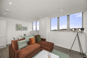 Living room with windows and sea view, featuring a double sofa and Smart TV
