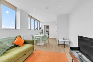 Living room with large window and sea view, featuring a double sofa and Smart TV