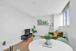 Living room with large window and sea view, featuring a double sofa and Smart TV