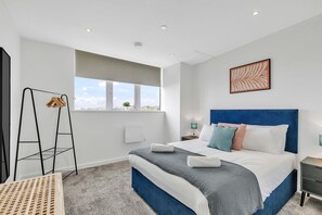 Bedroom with a double bed, neutral decor, and bright natural light