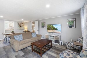 Enjoy a stylish and comfortable living room with beachy accents, patterned armchairs, and a welcoming ambiance.