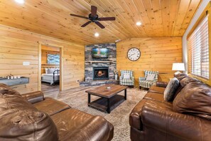 Open living area with leather seating, fireplace, and Smart TV