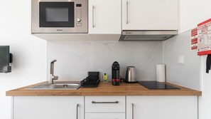 Whip up your favorite meals in this modern kitchenette equipped with everything you need for a stress-free stay. #ModernConvenience #KitchenGoals