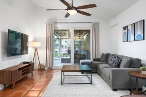 Airy living space featuring a cozy sofa set, Smart TV, and a direct backyard access