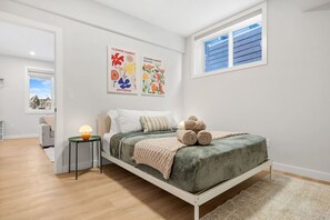 Queen bedroom with medium firm memory foam mattress & a cozy night lamp.