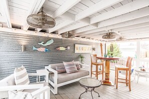 Expansive side patio with tv, oversized patio furniture and a bistro dining set