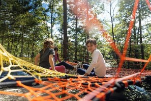 Play on a net woven between trees!