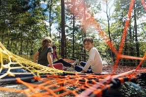Play on a net woven between trees!