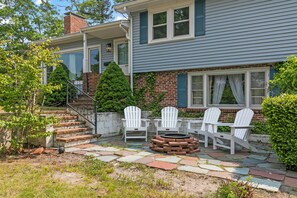 Cozy firepit with Adirondack chairs & pond views—perfect for relaxing nights!