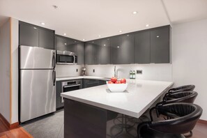 Modern kitchen with stainless steel appliances and breakfast bar seating