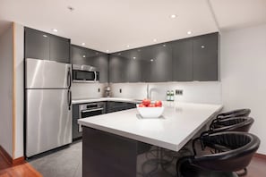 Modern kitchen with stainless steel appliances and breakfast bar seating