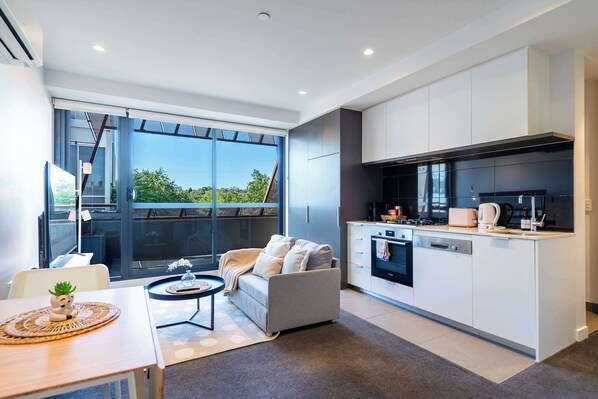 Living room with open kitchen, sofa bed and smart TV