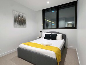 The 2nd bedroom with a queen sized bed & plush pillows.