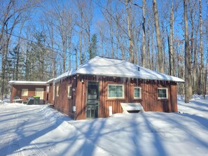OVERALL:  A broader view of the front of the cabin in winter.