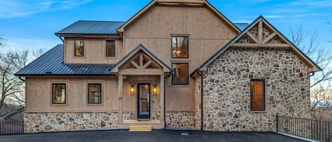 Welcome to Wellevate Lodge, a luxurious Smoky Mountain escape! With its rustic wood and stone exterior, metal roof, and warm lighting, this cabin is the perfect blend of modern elegance and mountain charm.