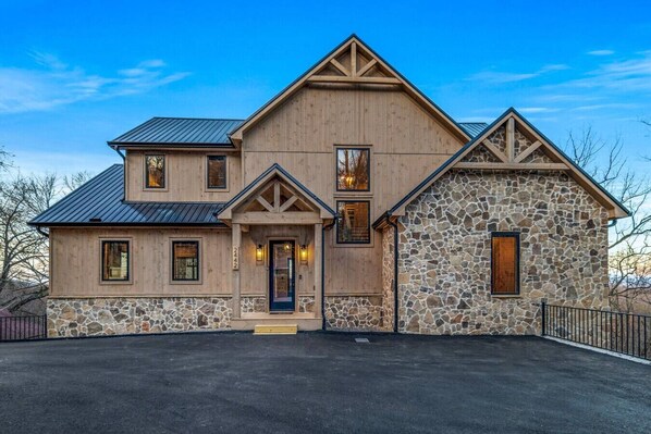 Welcome to Wellevate Lodge, a luxurious Smoky Mountain escape! With its rustic wood and stone exterior, metal roof, and warm lighting, this cabin is the perfect blend of modern elegance and mountain charm.