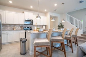 Modern kitchen with stainless steel appliances, island seating, and sleek design.