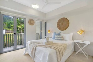 The primary bedroom highlights a queen size bed and a private balcony. It also offers an ensuite bathroom with a walk-in robe.