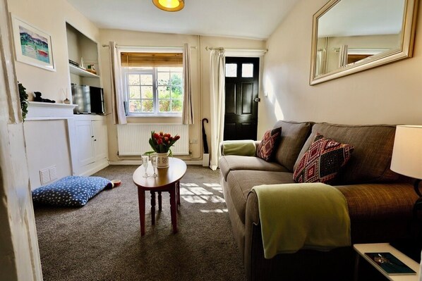 Cosy living room with soft lighting, comfy sofa and Netflix-ready Smart TV.
