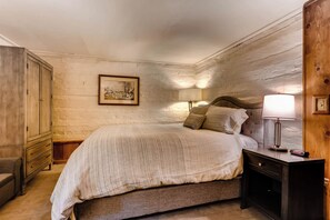 Rustic elegance meets modern comfort in this warmly lit bedroom, featuring cozy bedding and wood accents.
