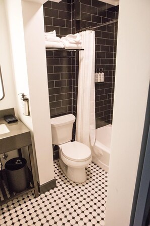 Chic and compact bathroom with a sleek black-and-white design, blending modern aesthetics with timeless elegance.
