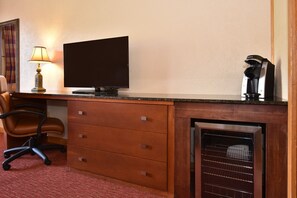 Functional workspace with a sleek desk, flat-screen TV, and a convenient coffee station for a comfortable stay.