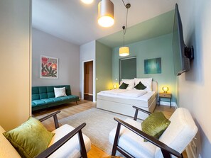 Green bedroom with double bed and sofa bed