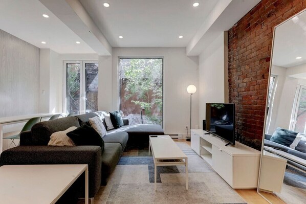 Step into a bright living area with exposed brick accents and a warm, inviting vibe