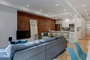 Another angle shows off the warm brick accent and modern furnishings, adding character to every corner