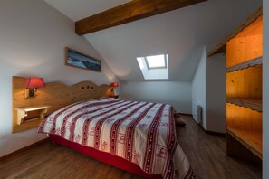 Cozy bedroom nestled under the eaves, creating a warm and intimate ambiance for a peaceful night’s sleep.