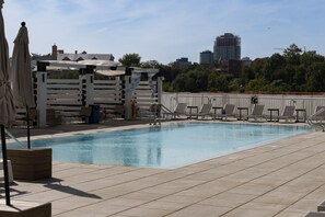Outdoor infinity pool, lounge chairs, umbrellas and cabanas