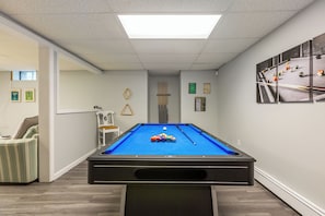 Basement with a game room including a pool table, foosball, smart TV and more!