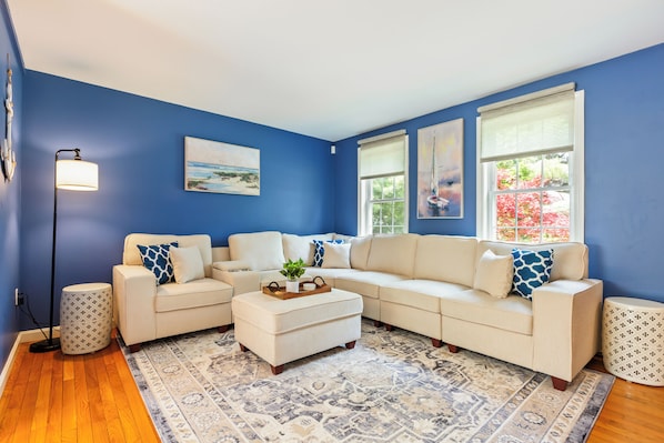 Cozy living room with sectional, smart TV and board games.