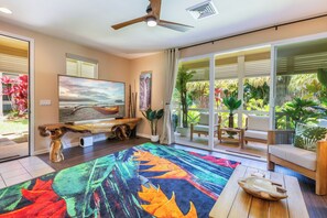 The bright and open living room features plenty of natural light and tropical decor.