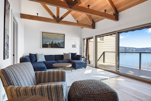 Open living space with lake view, TV, and fireplace